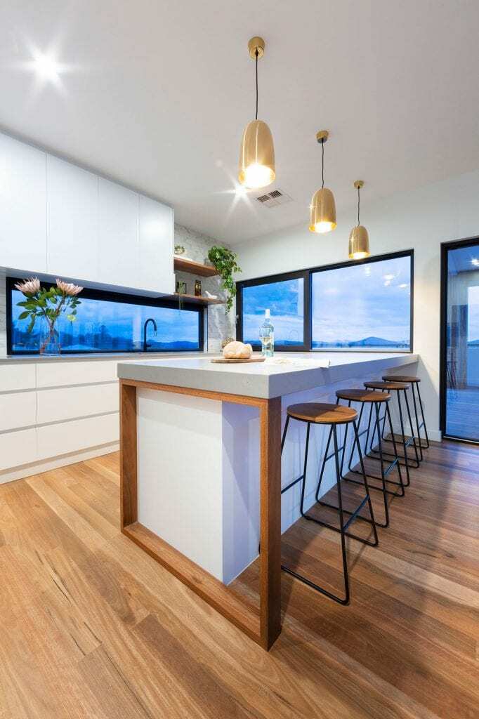 Homes by Howe, new build, Denman, kitchen, 3 pendant lights hang over kitchen island low surrounding windows look out onto Molongolo valley
