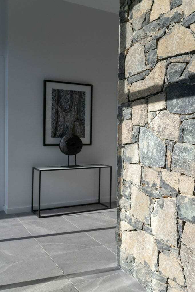 Homes by Howe, knock down rebuild, Deakin, open plan living area looking out onto courtyard pool, drystone wall fireplace
