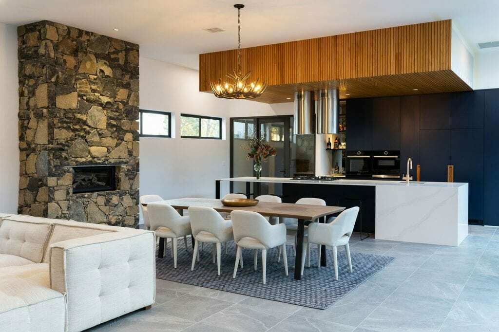 Homes by Howe, knock down rebuild, Deakin, open plan living area looking out onto courtyard pool, drystone wall fireplace