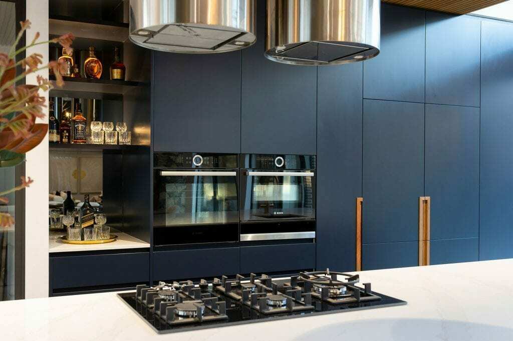 Homes by Howe, knock down rebuild, Deakin, kitchen, navy blue cabinetry with white talostone benchtops and gold facets, large central island with slatted wood detailing on ceiling above
