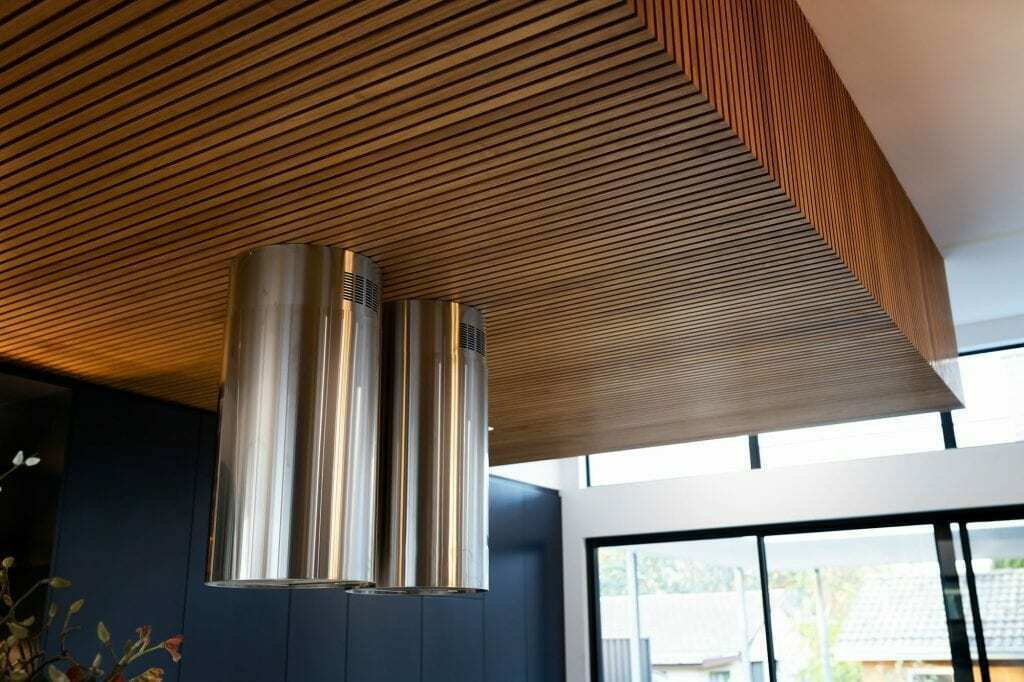 Homes by Howe, knock down rebuild, Deakin, kitchen, navy blue cabinetry with white talostone benchtops and gold facets, large central island with slatted wood detailing on ceiling above