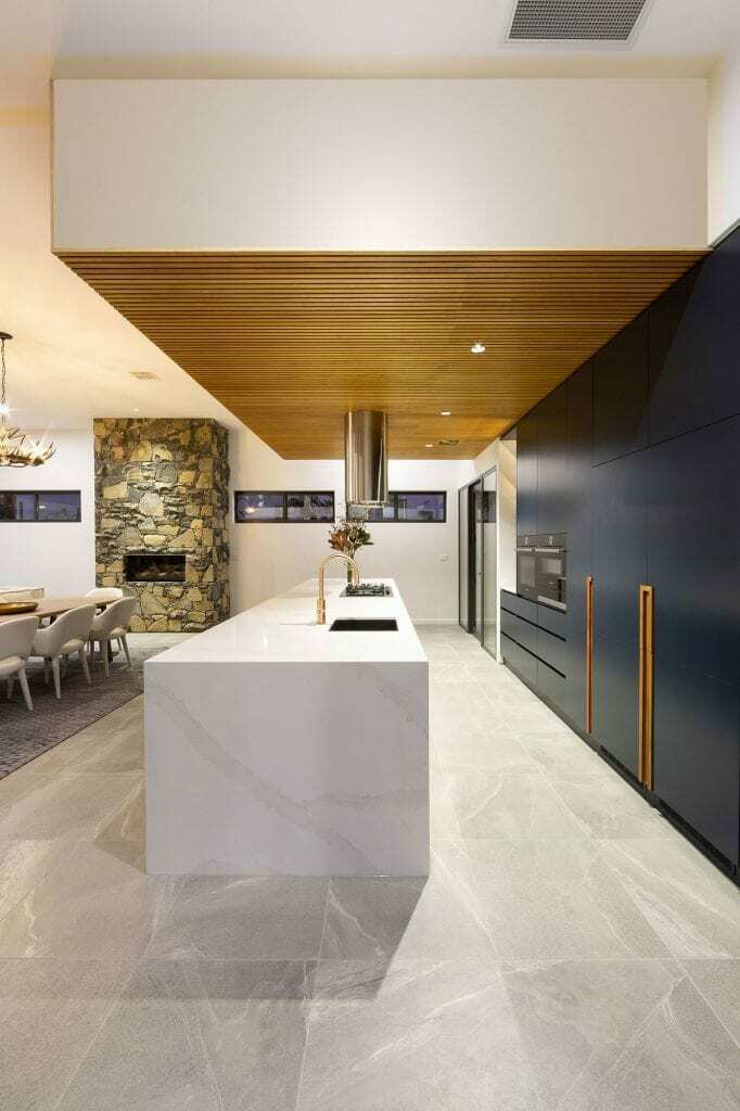 Homes by Howe, knock down rebuild, Deakin, open plan living area looking out onto courtyard pool, drystone wall fireplace
