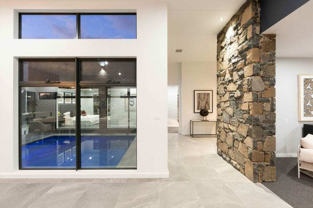 Homes by Howe, knock down rebuild, Deakin, dry stone wall on right, window looking out to courtyard pool, grey tiles