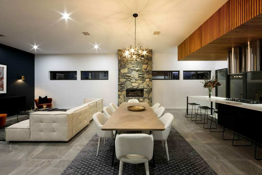 Homes by Howe, knock down rebuild, Deakin, open plan living area looking out onto courtyard pool, drystone wall fireplace