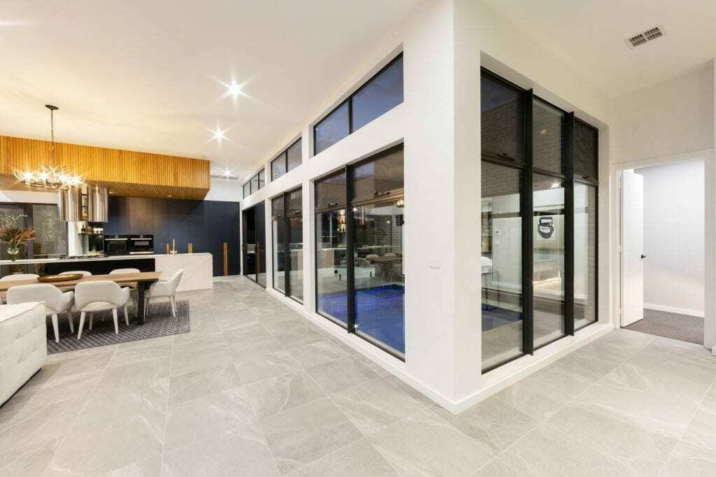 Homes by Howe, knock down rebuild, Deakin, open plan living area looking out onto courtyard pool, drystone wall fireplace