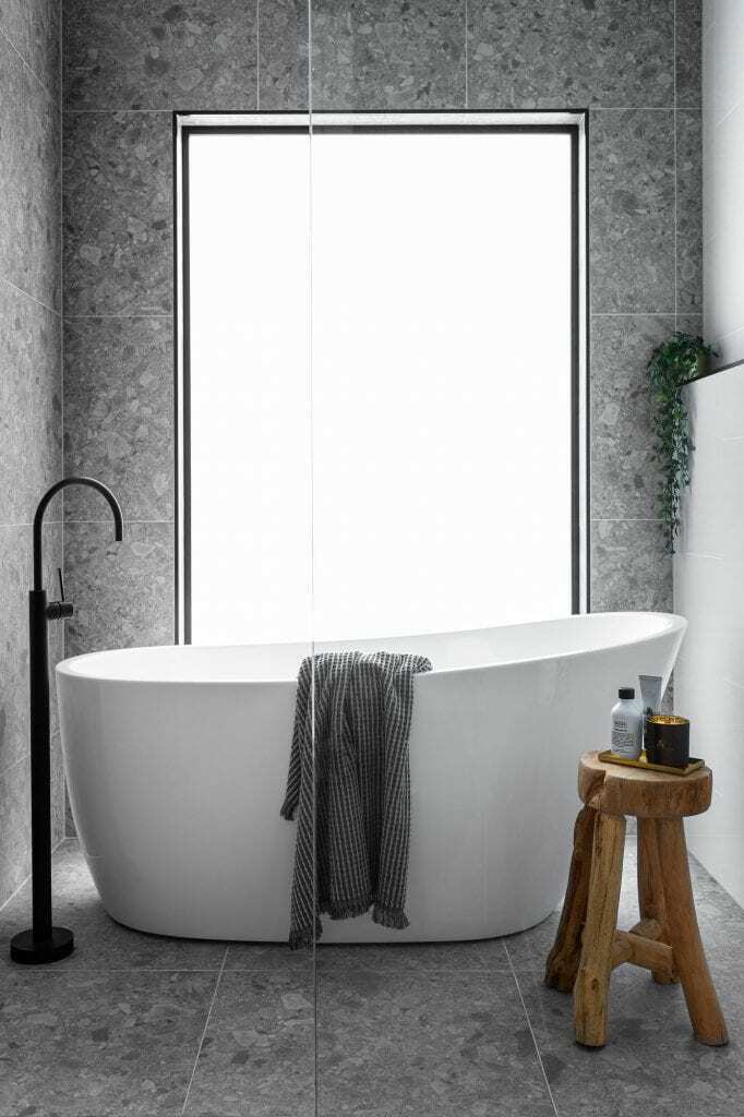 Homes by Howe, new build, Denman, bathroom, freestanding bath infront of large window, grey tiling, black freestanding tap