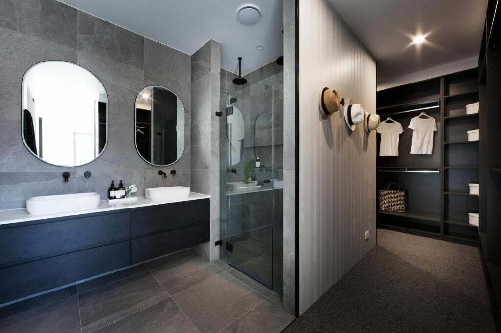 Homes by Howe, knock down rebuild, Red Hill, bathroom and walk in wardrobe, grey slate tiling in bathroom, glass inbuilt shower and weathertex white architectural panelling on walk in wardrobe entry wall