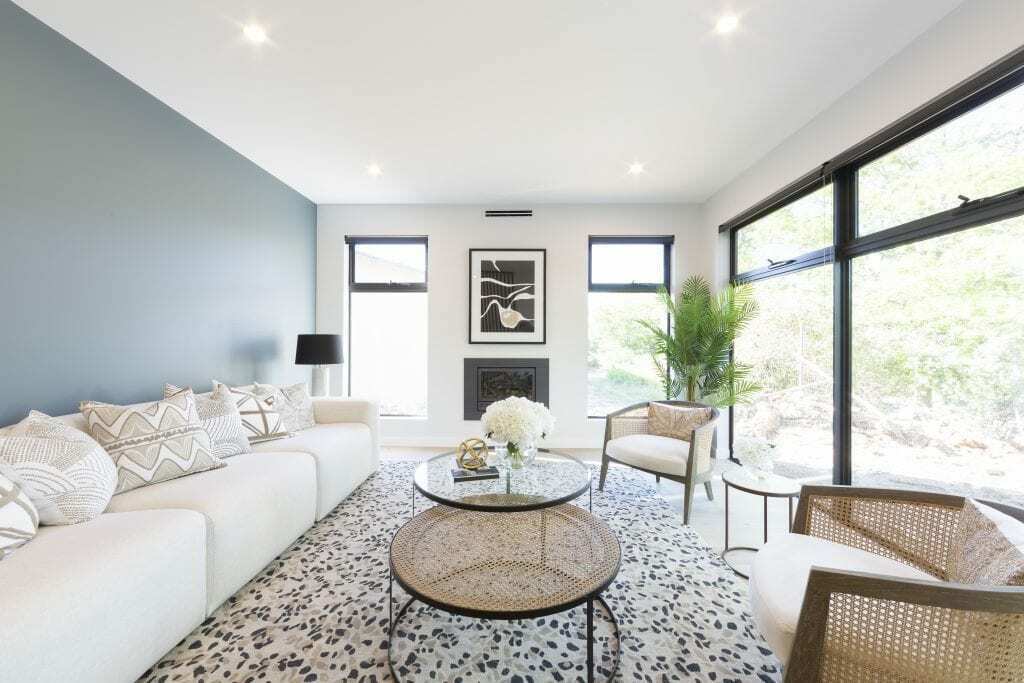 Homes by Howe, knock down rebuild, Red Hill, living room, green feature wall, sofa and two circular glass coffee tables, fireplace and windows
