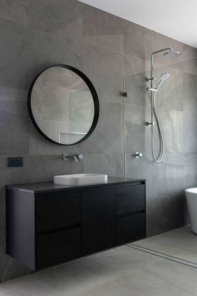 Homes by Howe, knock down rebuild, Red Hill, bathroom, grey, slate tiling, circular mirror, black vanity and white basin