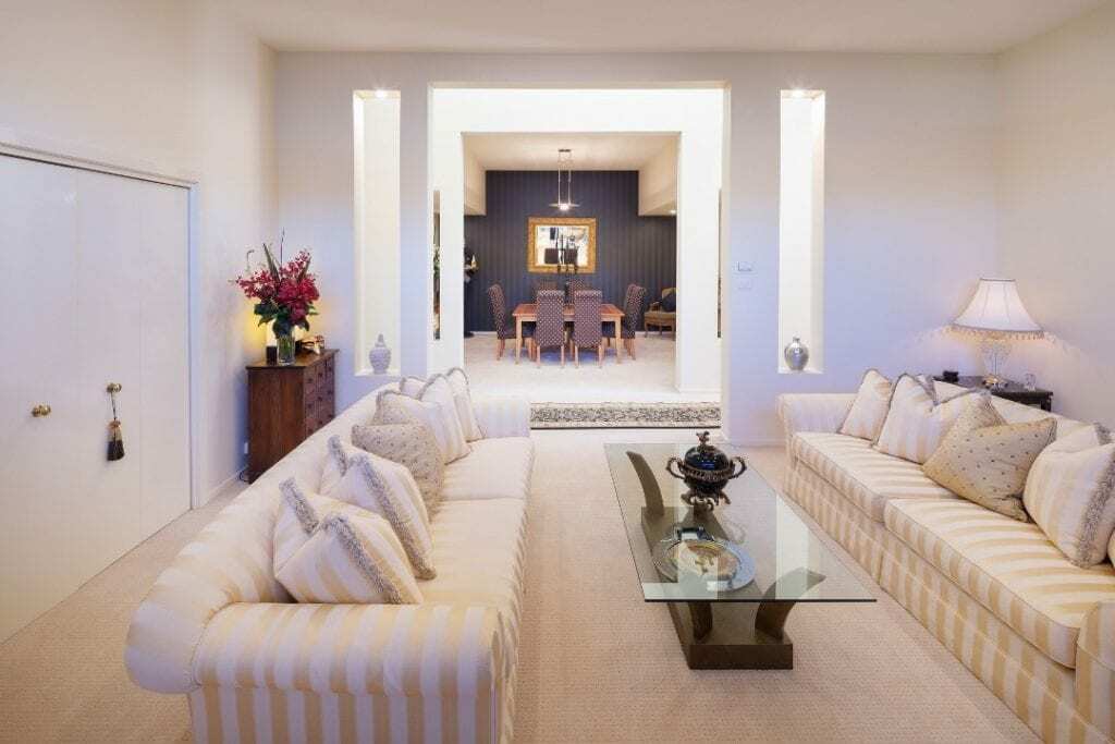Homes by Howe, renovation, Griffith, living room, large cream sofa and cream carpet looking into dining room