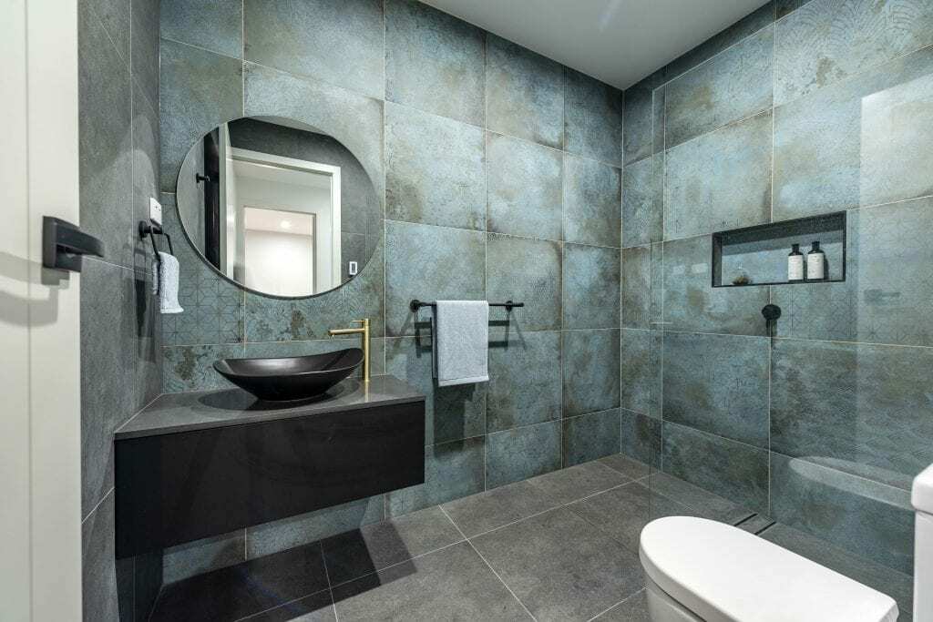 Homes by Howe, new build, Denman, bathroom, green tiling, circular mirror, black vanity