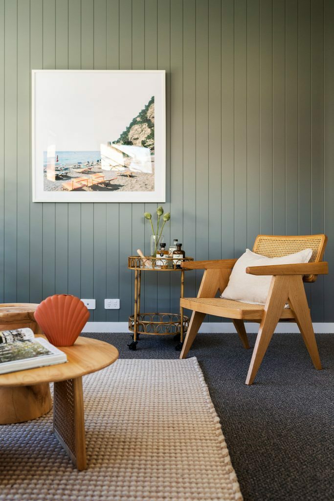 Homes by Howe, knock down rebuild, Chapman, living room, green weathertex panelling behind wooden chair