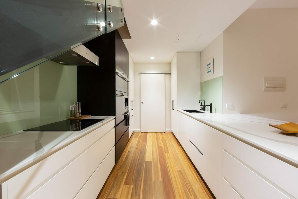 Homes by Howe, renovation, Braddon, kitchen, light wooden floorboard, green splashback, galley style kitchen in a compact space