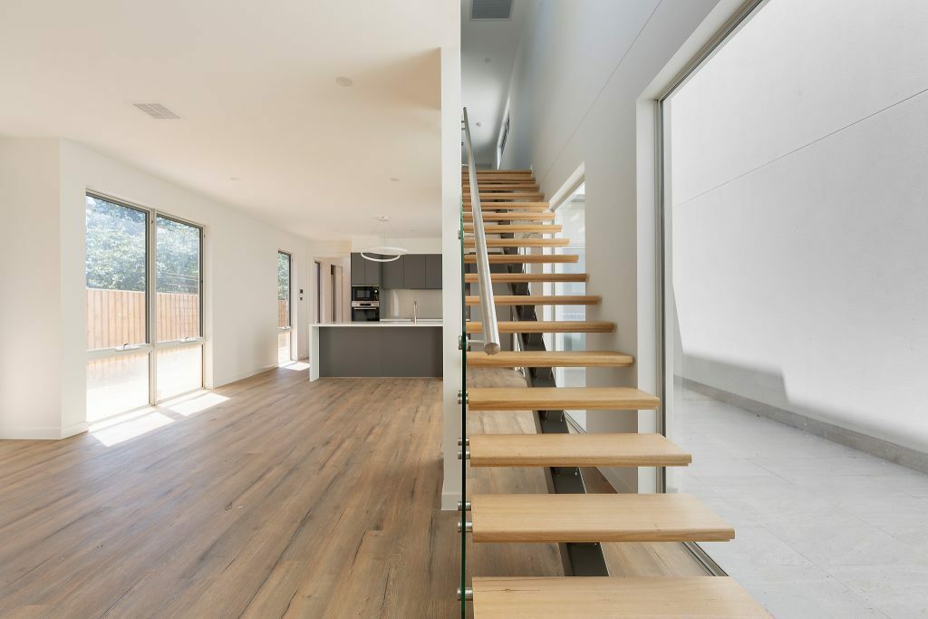 Homes by Howe, Canberra builder, dual occupancy, knock down rebuild, O'Connor, open plan living area, spine-back staircase with view back towards kitchen