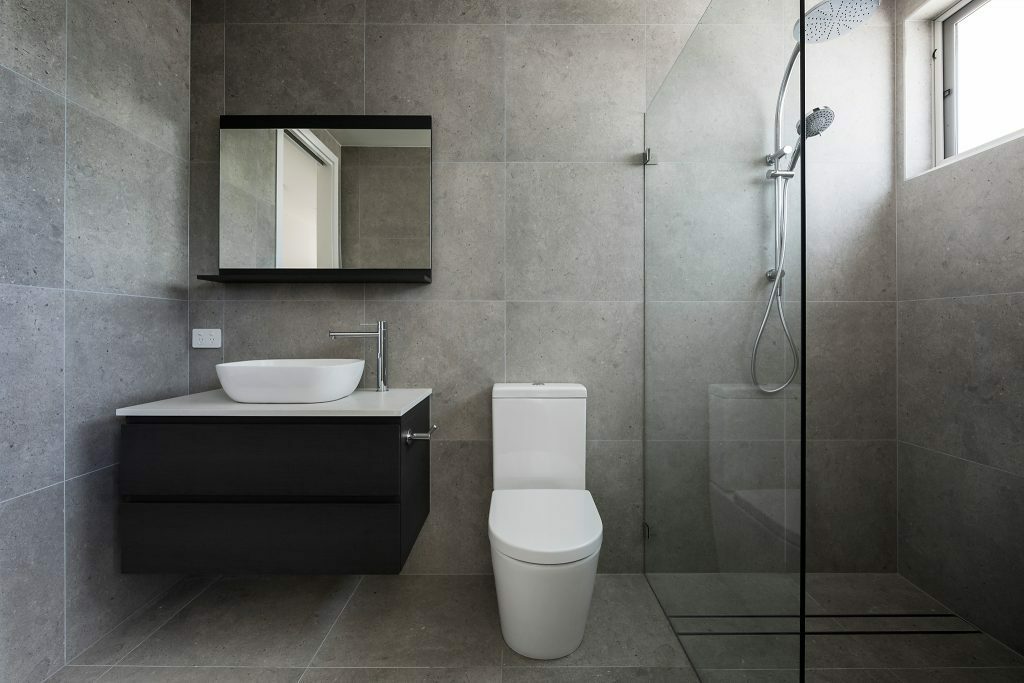 Homes by Howe, Canberra builder, dual occupancy, knock down rebuild, O'Connor, bathroom, dual sink vanity, grey floor to ceiling tiling, large shower and slot window