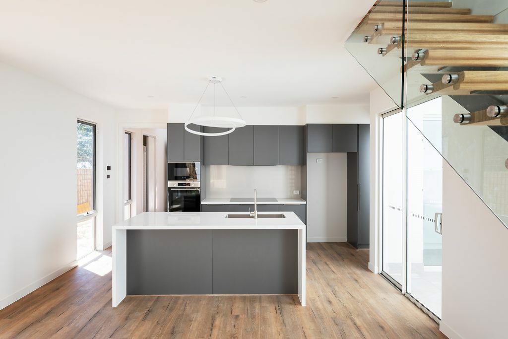 Homes by Howe, Canberra builder, dual occupancy, knock down rebuild, O'Connor, kitchen and open plan living view, spine-back staircase, floor boards and large floor to ceiling windows