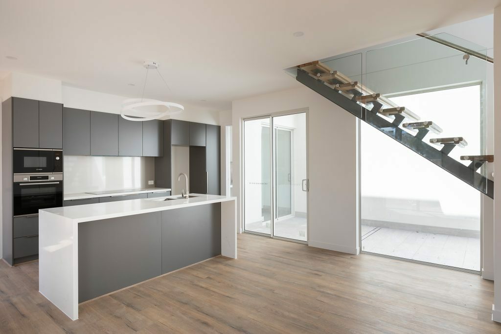 Homes by Howe, Canberra builder, dual occupancy, knock down rebuild, O'Connor, kitchen and open plan living view, spine-back staircase, floor boards and large floor to ceiling windows